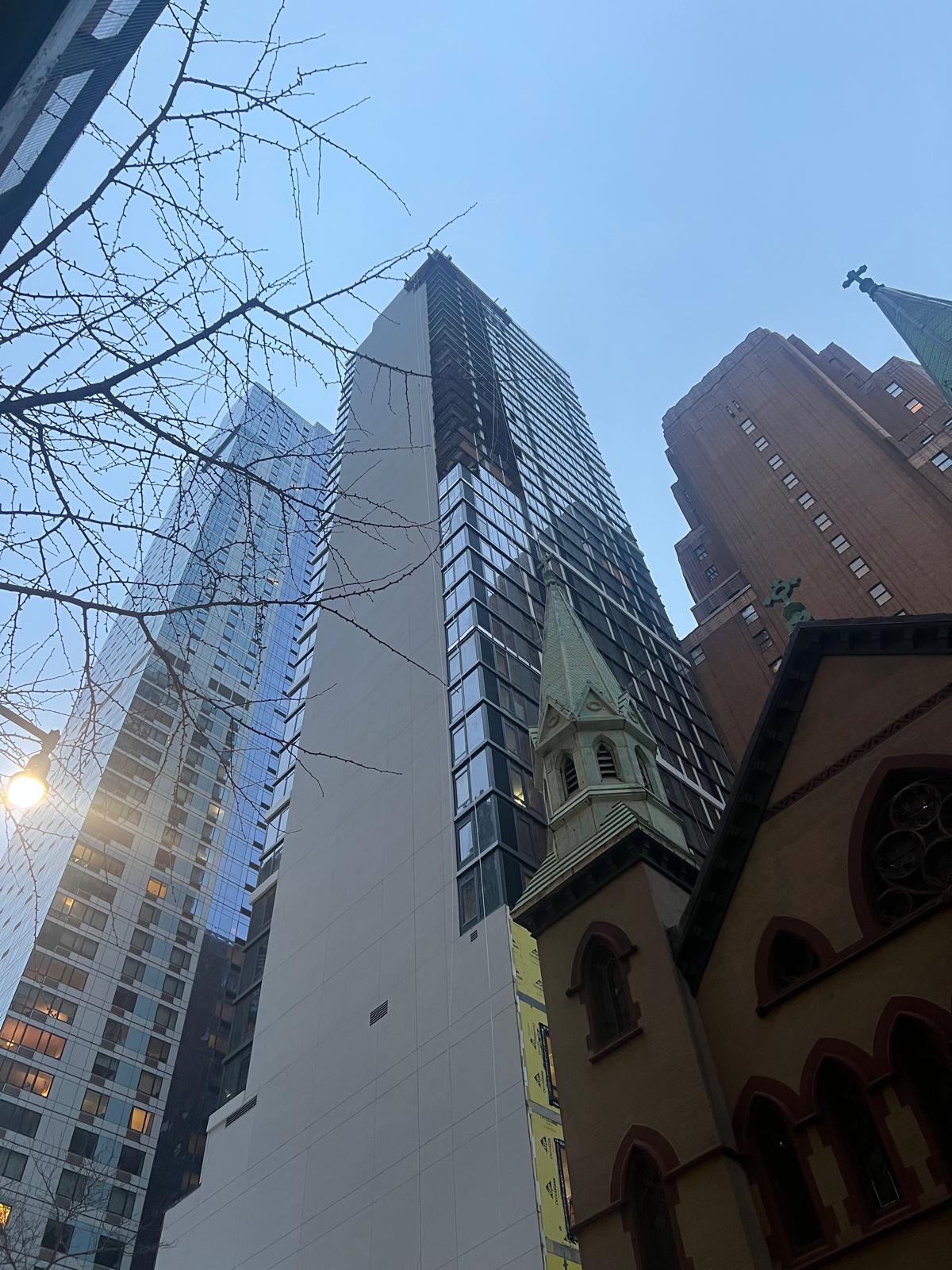 111 Willoughby Street tower exterior beside neighboring Brooklyn buildings